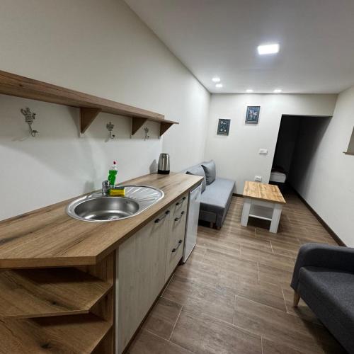 a bathroom with a sink and a living room at Белчини in Dobrinishte