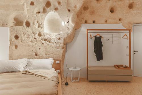 a bedroom with a bed and a stone wall at La Dimora Di Metello in Matera