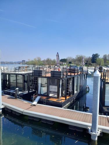 a dock with a house on the water at Floating Experience Black Pearl, Lago Maggiore in Dormelletto