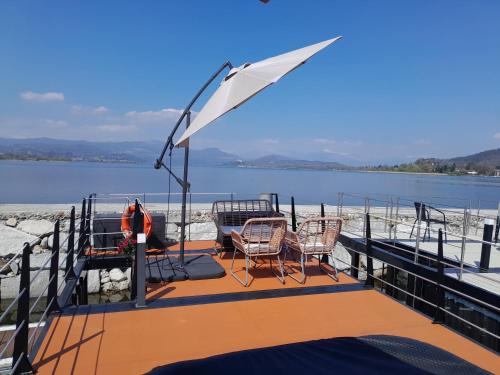 a deck of a boat with chairs and an umbrella at Floating Experience Black Pearl, Lago Maggiore in Dormelletto