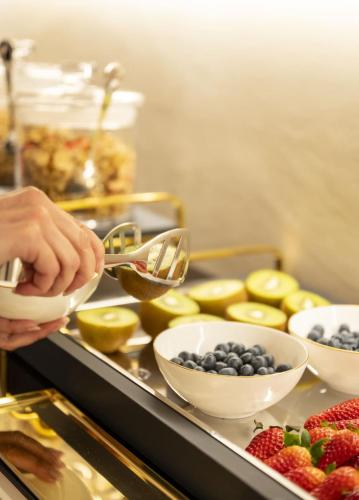 a person is preparing food with bowls of fruit at Residenza d'epoca Luca Pacioli in Sansepolcro