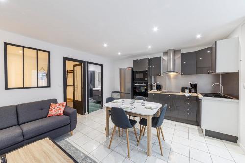 Il comprend un salon et une cuisine avec une table et un canapé. dans l'établissement Le Carnot's - Wifi - Proche port, à Cancale