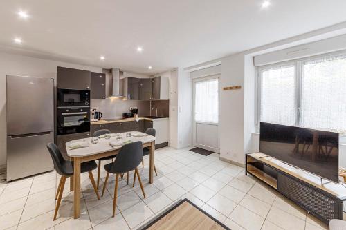 une cuisine avec une table et des chaises dans une pièce dans l'établissement Le Carnot's - Wifi - Proche port, à Cancale