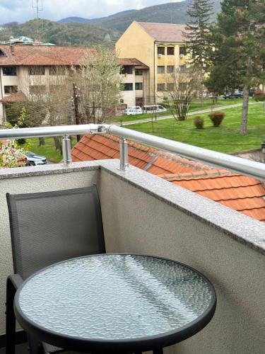 a table and a chair on a balcony at Cvetkovic apartman in Soko Banja