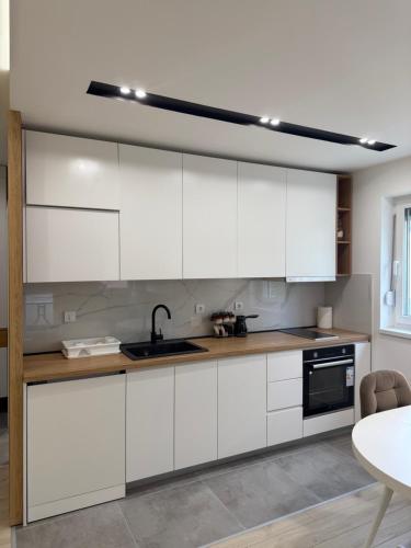 a kitchen with white cabinets and a sink at Cvetkovic apartman in Soko Banja