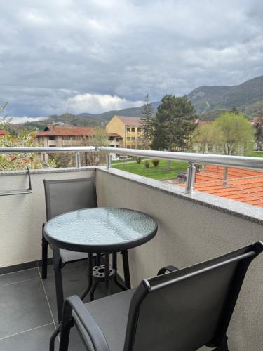 a table and chairs on a balcony with a view at Cvetkovic apartman in Soko Banja