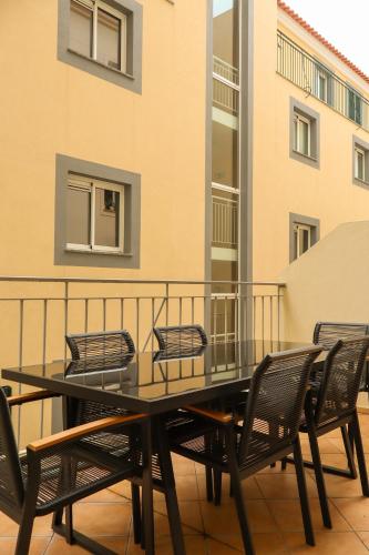 a black table and chairs on a balcony at Suites Do Carmo in Funchal