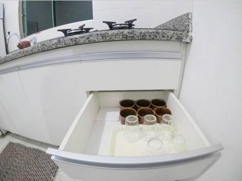 a drawer in a bathroom with three cups in it at Chalés paradise - Família in Serra do Cipo