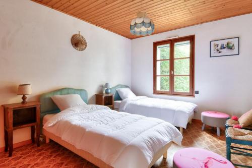 une chambre avec deux lits et une fenêtre dans l'établissement Maison avec jardin à 400m de la plage des Sableaux, à Noirmoutier-en-l'lle