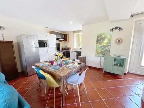 une cuisine avec une table et des chaises dans une pièce dans l'établissement La Maison des Hirondelles, à Lachelle