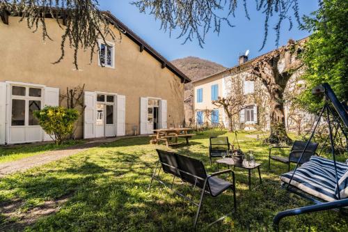 a garden with chairs and a table in front of a building at Vila Marisa in Ax-les-Thermes
