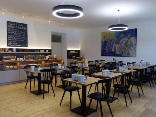 Zentrum für Umwelt und Kultur - Gästehaus und Jugendbildungseinrichtung im Maierhof في بينيديكتبيورن: غرفة طعام مع طاولات وكراسي وكاونتر