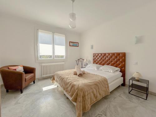 une chambre avec un grand lit et une chaise dans l'établissement Spacieux T3 avec terrasse à Fréjus, à Fréjus
