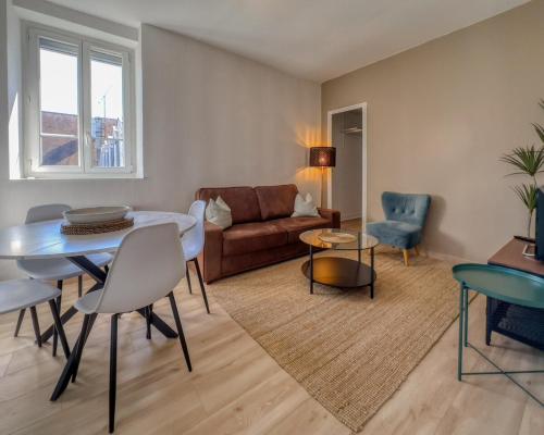 a living room with a table and chairs and a couch at le harley haven in Compiègne