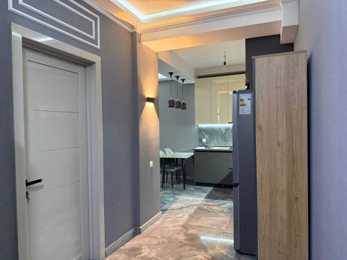 a hallway with a door and a room with a kitchen at Crystal Apartments in Tbilisi City