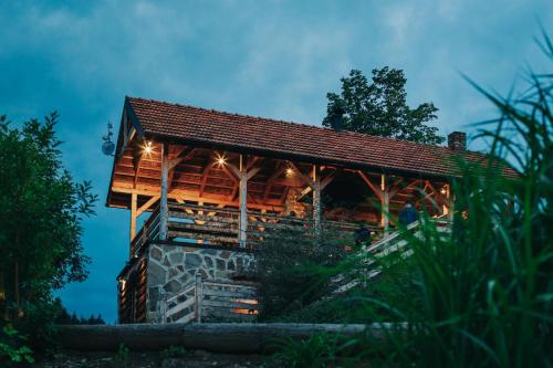 a wooden building with lights on it at night at Jeżowa Woda Ośrodek Wypoczynkowy Palmiarnia i SPA in Przyszowa