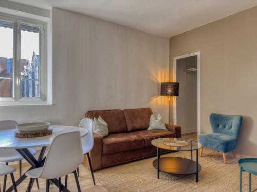 a living room with a couch and a table and chairs at le harley haven in Compiègne