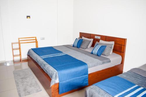 a bedroom with two beds with blue and gray pillows at Flaming Tree Resorts in Kiriwan Eliya