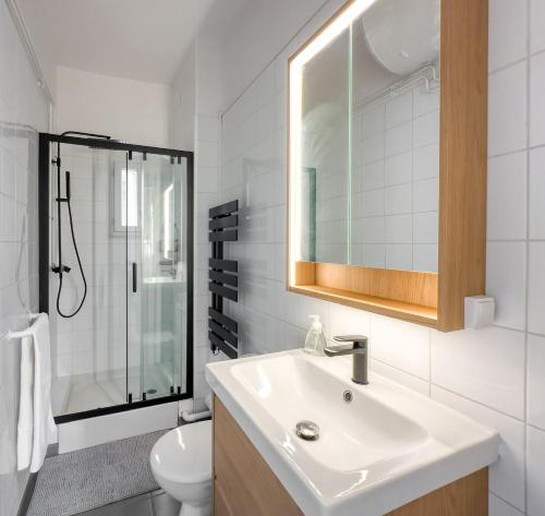 a white bathroom with a sink and a shower at le harley haven in Compiègne