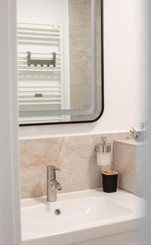 a bathroom sink with a mirror above a sink at Little Bucharest downtown apartments Romana in Bucharest
