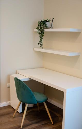 a white desk with a green chair and shelves at Little Bucharest downtown apartments Romana in Bucharest