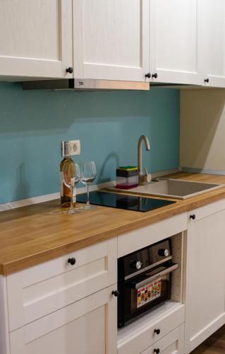 a kitchen with white cabinets and a sink at Little Bucharest downtown apartments Romana in Bucharest