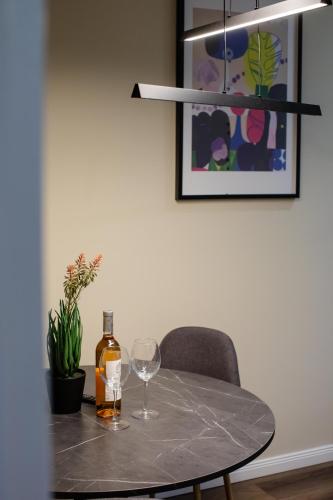 a table with a bottle of wine and a glass at Little Bucharest downtown apartments Romana in Bucharest
