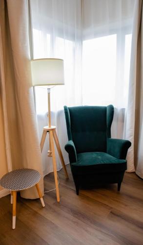 a living room with a green chair and a lamp at Little Bucharest downtown apartments Romana in Bucharest
