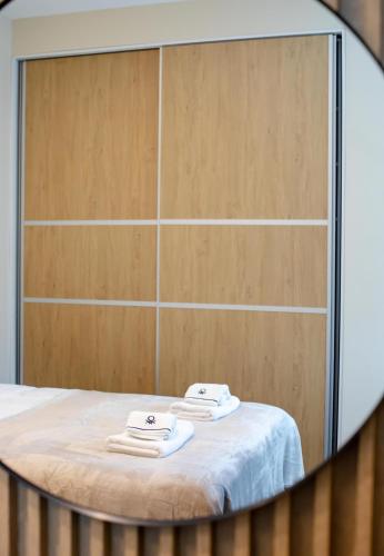 two towels on a bed in front of a mirror at Little Bucharest downtown apartments Romana in Bucharest