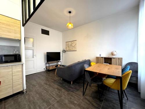 un salon avec une table, des chaises et une télévision dans l'établissement Appartement de 3 chambres, parking gratuit, proche métro, à Oullins