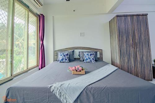 a bedroom with a bed with a basket of flowers on it at THE BLISS PALM in Mumbai