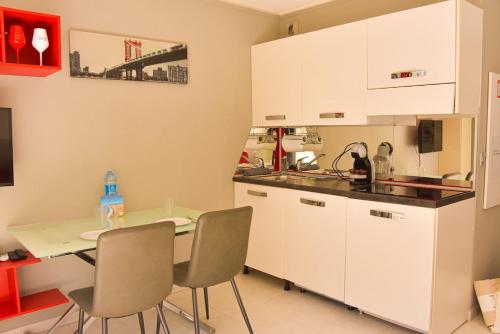 une cuisine avec des armoires blanches et une table et des chaises dans l'établissement Studio avec terrasse à Nice, à Nice
