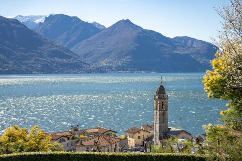 a town with a clock tower next to a body of water at Villa Principessa - Private Villa with Panoramic Lake Como Views in Cremia