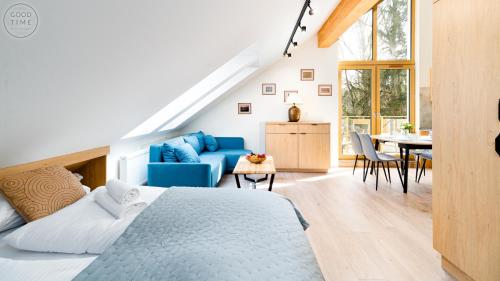 a bedroom with a blue bed and a dining room at Apartamenty Good Time- Mariental Residence - Centrum in Szklarska Poręba