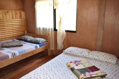 a bedroom with two twin beds and a window at Batad View Inn and Restaurant in Banaue