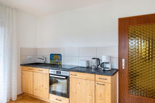 a kitchen with wooden cabinets and a stove top oven at Wildbiene bis 4 Pers in Freiensteinau