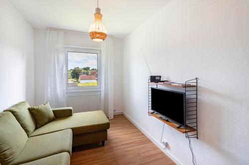 a living room with a couch and a flat screen tv at Wildbiene bis 4 Pers in Freiensteinau