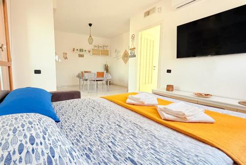 a bedroom with a large bed with a tv on the wall at Appartamento Da Elisa in Quartu SantʼElena