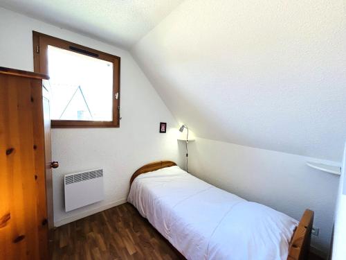 une petite chambre avec un lit et une fenêtre dans l'établissement Maisonnette 6 pers- Piscine commune - Plage à 500 m- LOEIZ, à Guidel-Plage