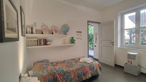 - une chambre avec un lit, des étagères et une fenêtre dans l'établissement Corsini House, à Levanto