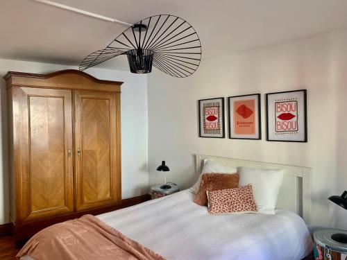 une chambre avec un lit et un lustre dans l'établissement Au petit Herz'og, à Wettolsheim