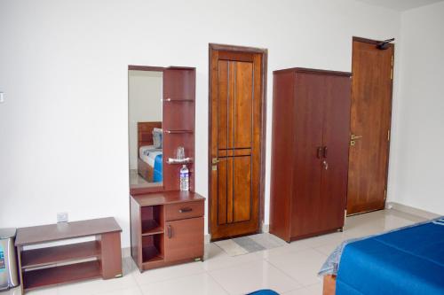 a living room with wooden furniture and a mirror at Flaming Tree Resorts in Kiriwan Eliya