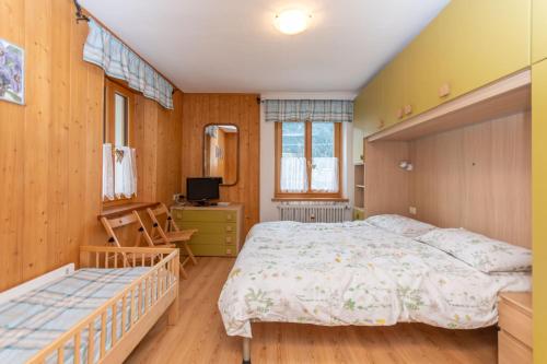 a bedroom with a bed and a desk and a television at Casa Col di Frena in Falcade