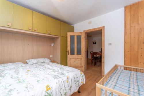 a bedroom with a bed and a dining room at Casa Col di Frena in Falcade