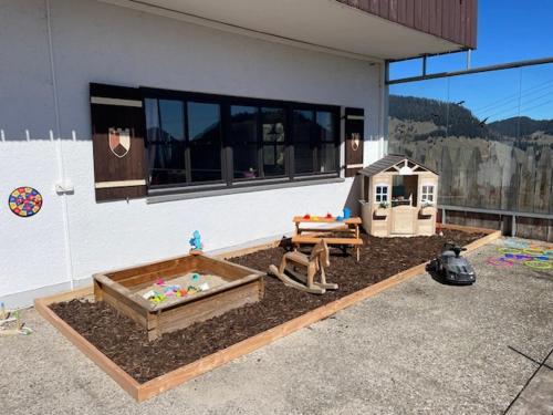 a backyard with a sandbox and a dog house at Almgasthof Grafenherberg in Oberaudorf