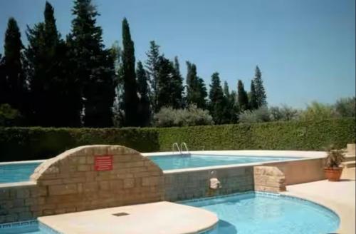 une piscine entourée d'un mur en pierre dans l'établissement Maisonnette en Provence, à Eyguières