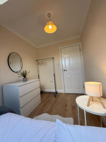 a bedroom with a bed and a mirror and a table at Redhill Residential in Redhill
