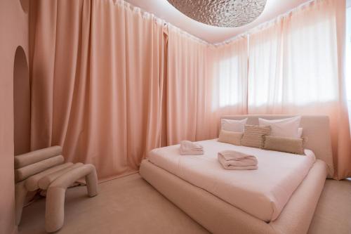 - une chambre avec des rideaux roses, un lit et une chaise dans l'établissement Le Boudoir Iconic 4 guests Cannes, à Cannes