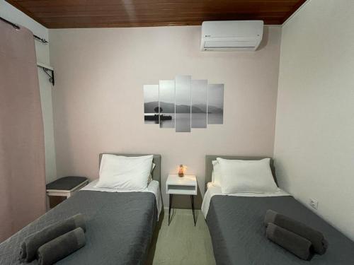 een kamer met 2 bedden en een tafel met een lamp bij Dada's Cottage in Argyrádes