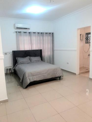 a bedroom with a bed in a white room at a home away from home in Trofwi